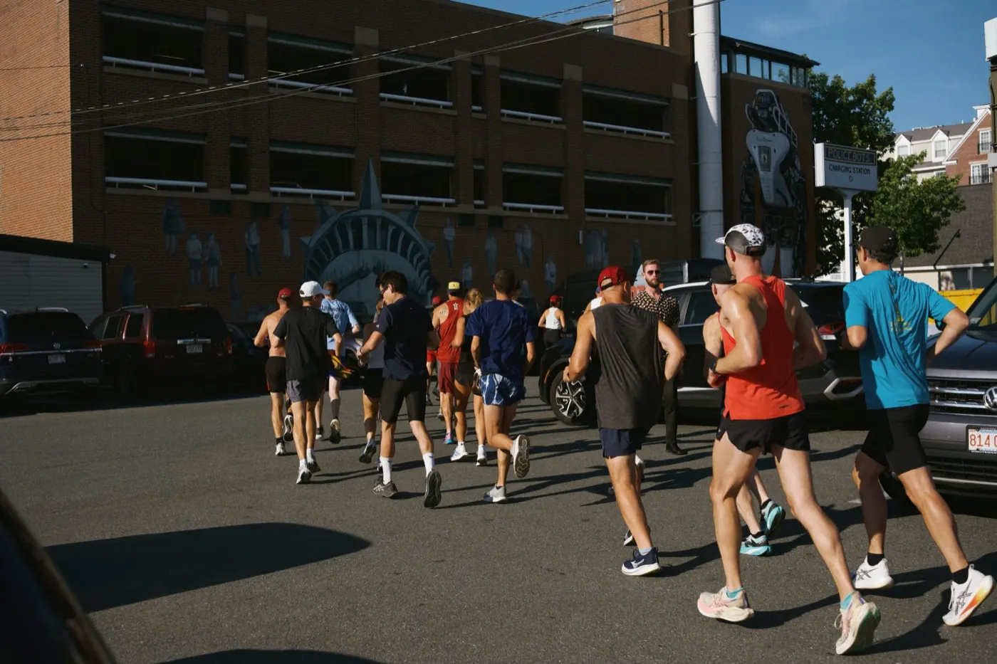 Group of runners heading down a city street on a community run